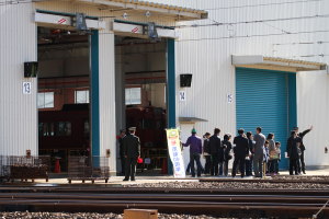 検車場内を案内されて歩く親子連れ